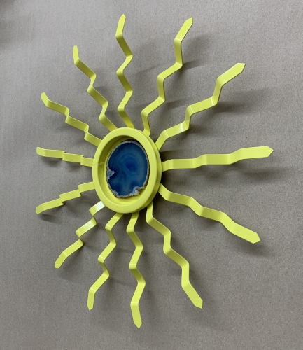 side view of yellow steel sun with blue geode